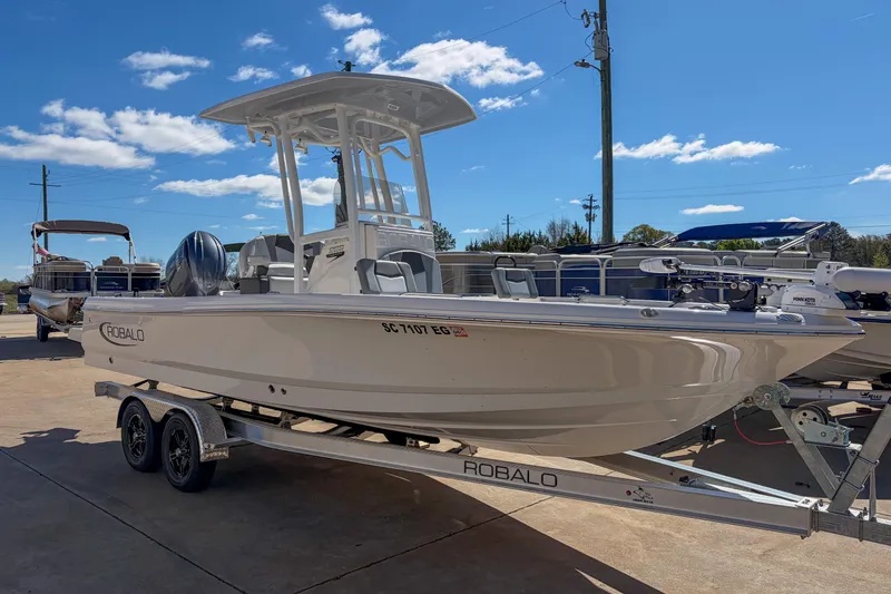 Slide: The Image of 2025 Robalo 226 Cayman boat on trailer under clear blue sky. - 14