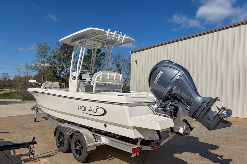 Slide: The Image of 2025 Robalo 226 Cayman boat with Yamaha engine on trailer, parked outdoors. - 3