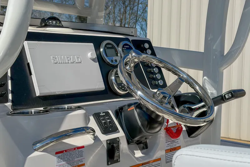 Slide: The Image of 2025 Robalo 226 Cayman boat dashboard with Simrad display and steering wheel. - 7