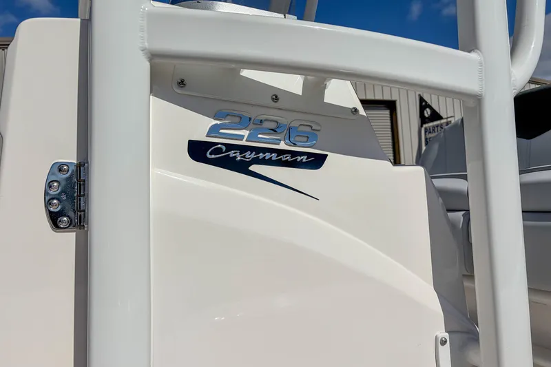 Slide: The Image of 2025 Robalo 226 Cayman boat detail with logo and hinge in sunlight. - 8