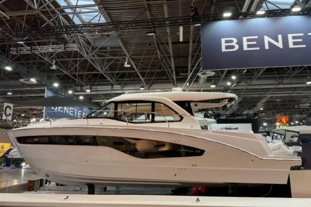The Image of 2026 Beneteau Antares 12 Coupe displayed at a boat show under bright lights. - 0