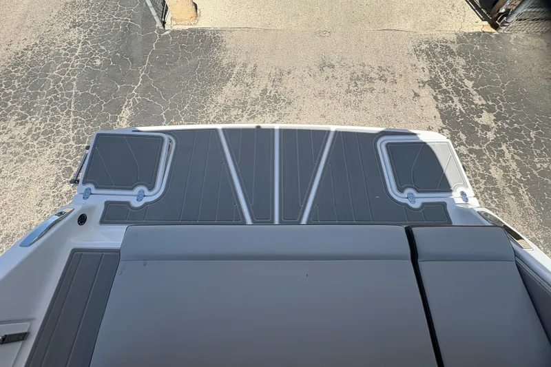 Slide: The Image of 2026 Monterey Elite 25 SD boat deck with gray padding and storage compartments. - 12