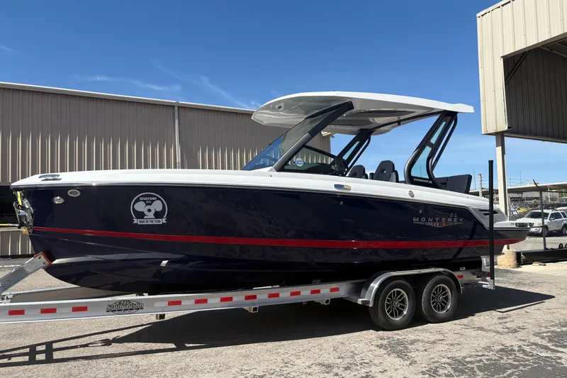Slide: The Image of 2026 Monterey Elite 25 SD boat on trailer, sleek design, navy hull, red stripe. - 4
