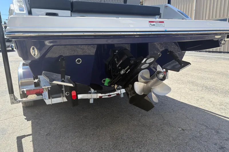 Slide: The Image of 2026 Monterey Elite 25 SD boat stern with propeller and trailer in sunlight. - 6