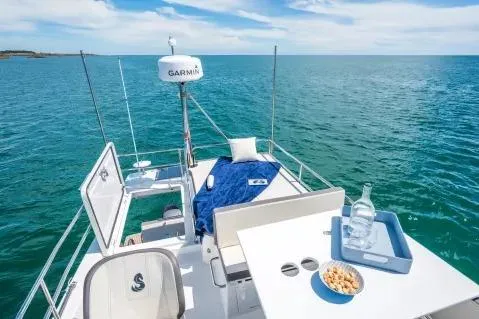 Slide: The Image of 2026 Beneteau Antares 11 Fly yacht deck with ocean view, featuring seating and refreshments. - 16