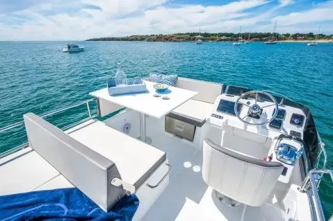 Slide: The Image of 2026 Beneteau Antares 11 Fly yacht interior with ocean view, featuring helm and seating area. - 17