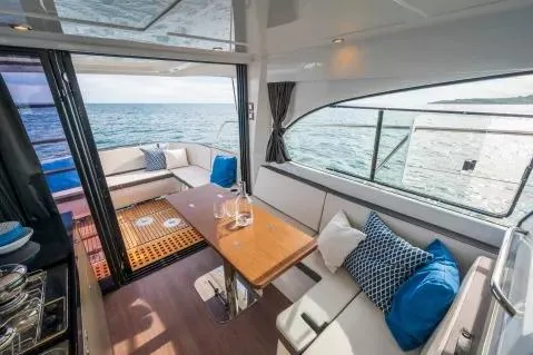 Slide: The Image of 2026 Beneteau Antares 11 Fly interior with ocean view, featuring elegant seating and dining area. - 5