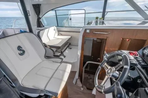 Slide: The Image of 2026 Beneteau Antares 11 Fly interior with helm, seating, and ocean view. - 7