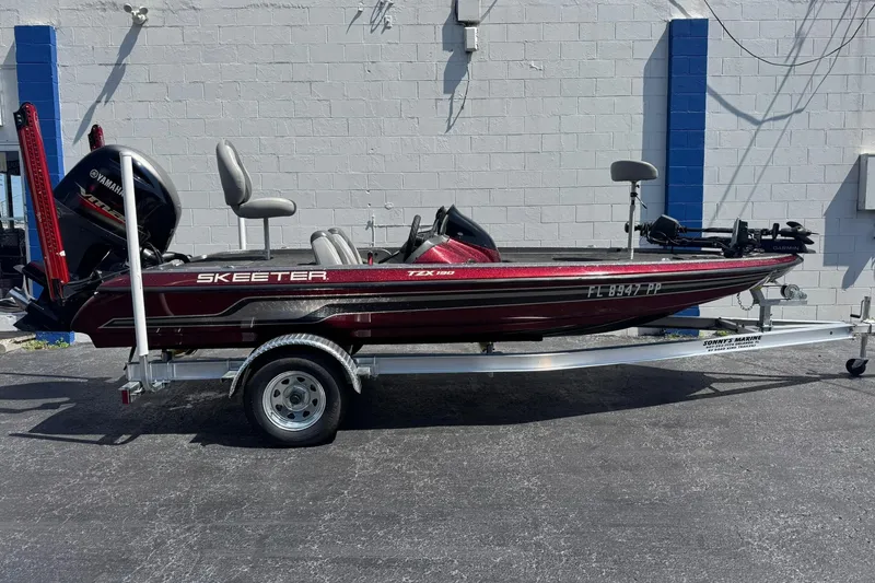 The Image of 2014 Skeeter TZX190 bass boat on trailer, featuring Yamaha engine, parked outdoors. - 0