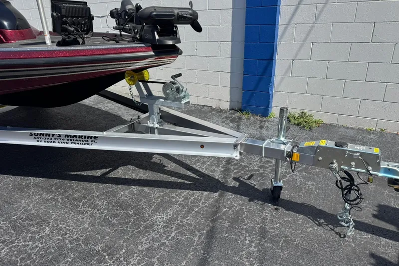 Slide: The Image of 2014 Skeeter TZX190 boat on trailer, parked near a white and blue wall. - 8