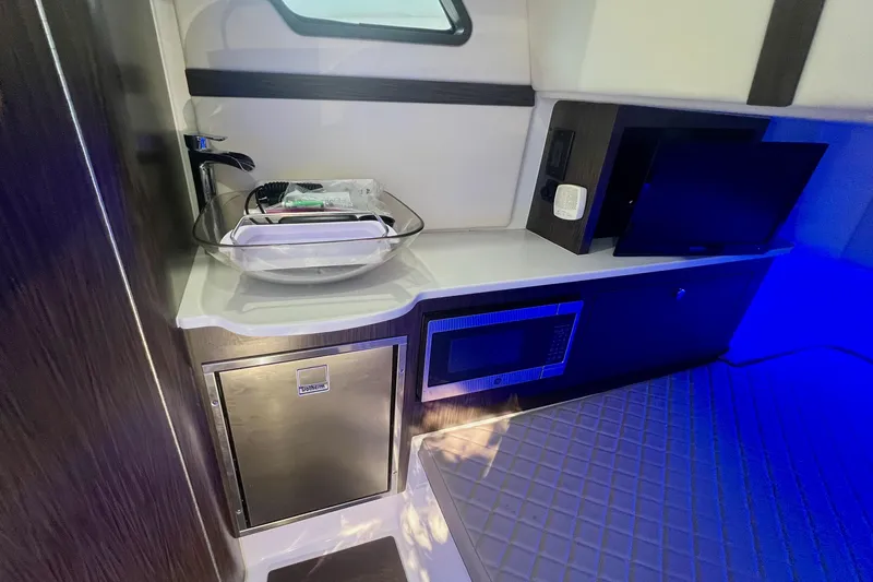 Slide: The Image of 2020 Edgewater 370CC cabin interior with sink, microwave, and ambient lighting. - 14