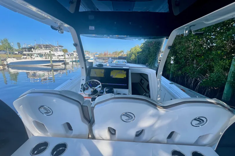 Slide: The Image of 2020 Edgewater 370CC boat interior with helm, steering wheel, and navigation screens. - 19