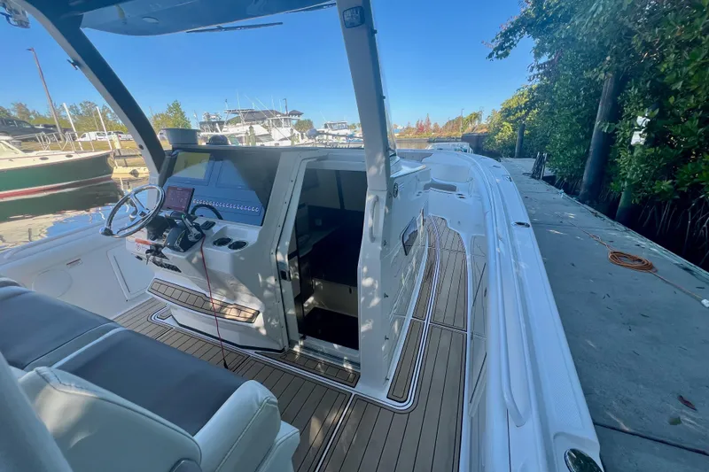 Slide: The Image of 2020 Edgewater 370CC boat interior with helm, docked at marina. - 20