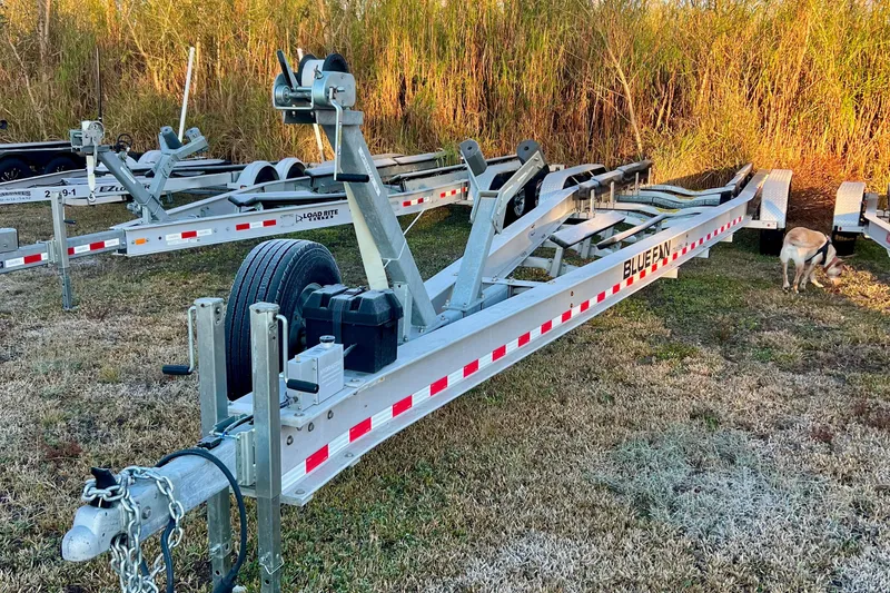 Slide: The Image of Boat trailer for 2020 Edgewater 370CC, parked on grass with a dog nearby. - 22