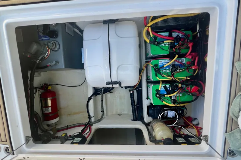 Slide: The Image of 2020 Edgewater 370CC boat battery compartment with wiring and fire extinguisher. - 26