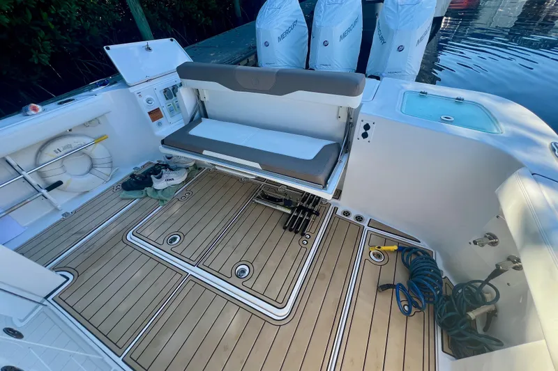 Slide: The Image of 2020 Edgewater 370CC boat interior with teak flooring and foldable seating. - 27