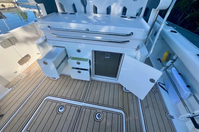 Slide: The Image of 2020 Edgewater 370CC boat interior with open storage compartments and teak flooring. - 28