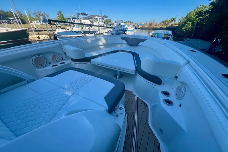 Slide: The Image of 2020 Edgewater 370CC boat interior with seating and table, docked at a marina. - 31