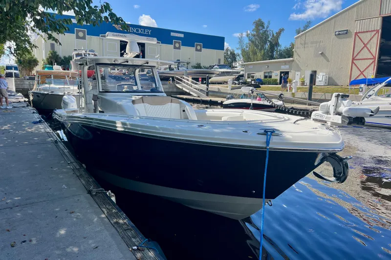 Slide: The Image of 2020 Edgewater 370CC boat docked at marina under clear blue sky. - 4