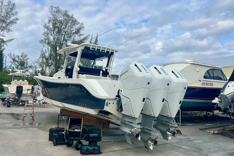 Slide: The Image of 2020 Edgewater 370CC boat with triple Mercury outboard engines in a marina setting. - 8