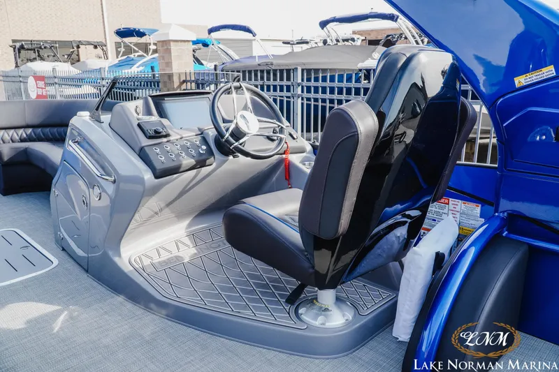 Slide: The Image of 2025 Bennington 25QXSBA boat interior with modern helm and seating at Lake Norman Marina. - 11