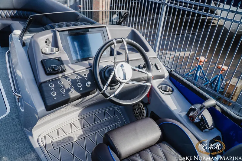 Slide: The Image of 2025 Bennington 25QXSBA boat dashboard with steering wheel and control panel at Lake Norman Marina. - 12