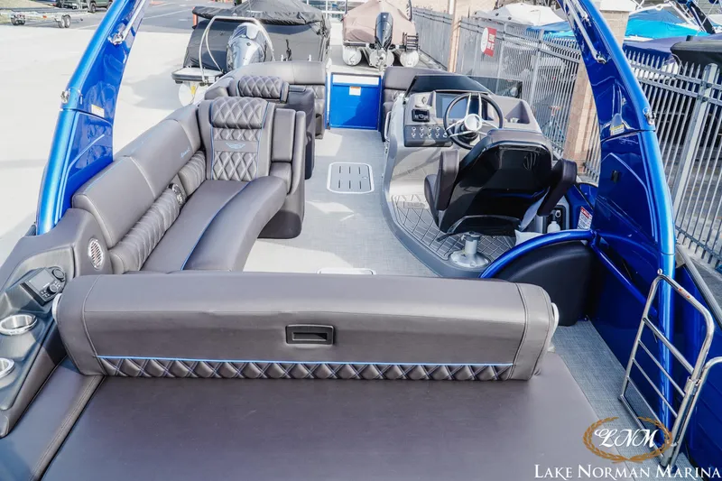 Slide: The Image of 2025 Bennington 25QXSBA luxury pontoon boat interior with plush seating at Lake Norman Marina. - 8