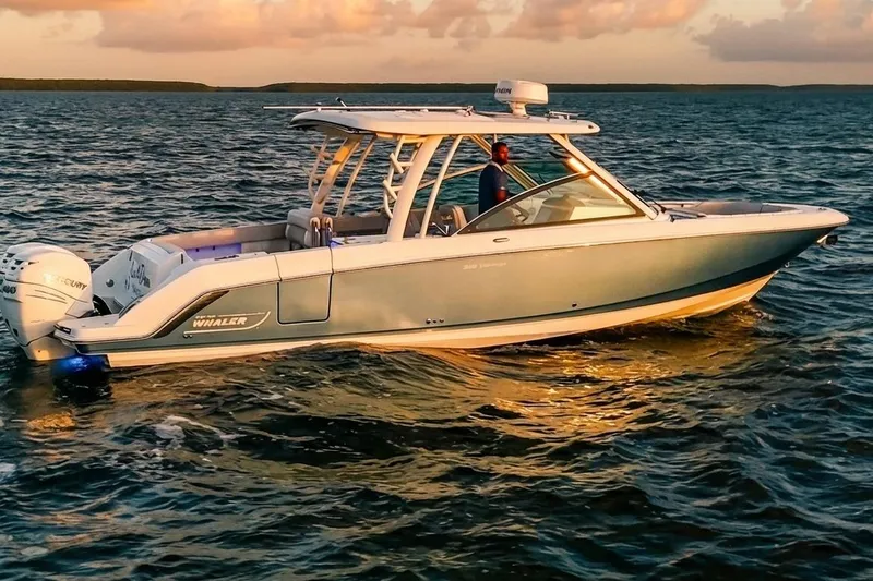 Slide: The Image of 2019 Boston Whaler 320 Vantage boat cruising on open water at sunset. - 11