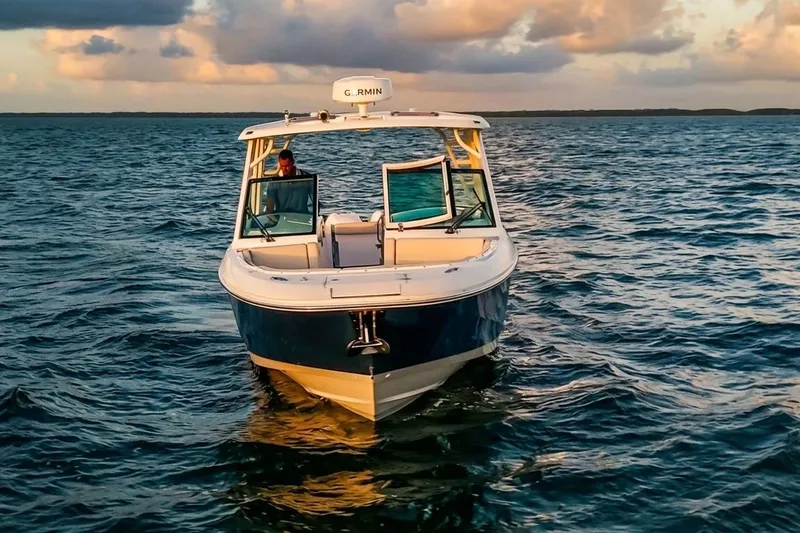 Slide: The Image of 2019 Boston Whaler 320 Vantage boat cruising on open water at sunset. - 13