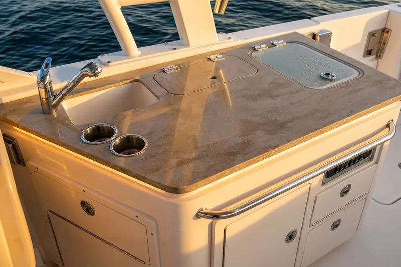 Slide: The Image of 2019 Boston Whaler 320 Vantage boat kitchen area with sink and storage. - 31