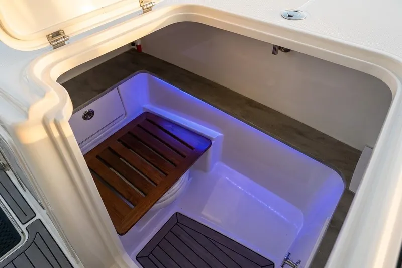 Slide: The Image of 2019 Boston Whaler 320 Vantage boat interior with wooden seat and blue LED lighting. - 44