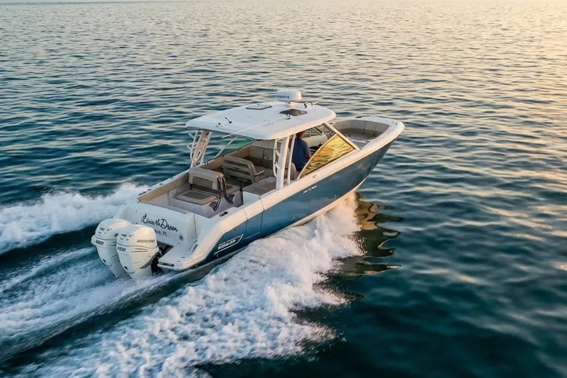Slide: The Image of 2019 Boston Whaler 320 Vantage cruising on open water at sunset. - 5