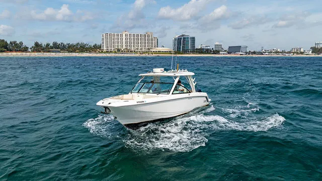 Slide: The Image of 2020 Boston Whaler 320 Vantage boat on open water under blue sky. - 50