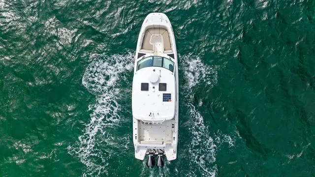 Slide: The Image of 2020 Boston Whaler 320 Vantage boat on clear turquoise water, aerial view. - 54