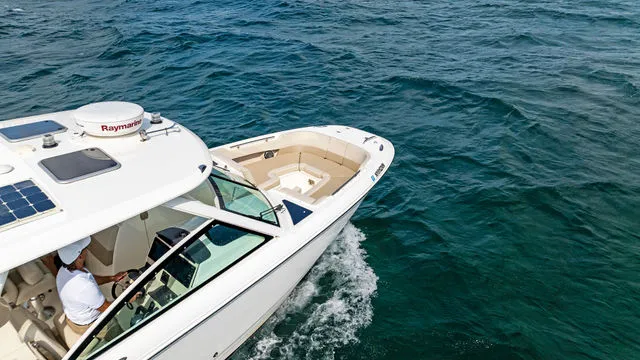 Slide: The Image of 2020 Boston Whaler 320 Vantage boat interior with seating, under clear blue sky. - 55