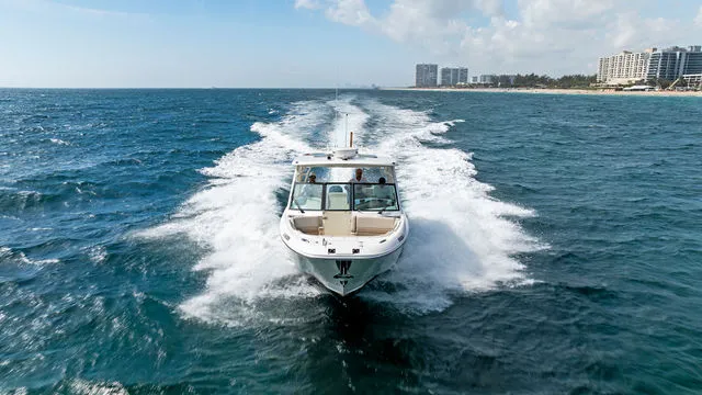 Slide: The Image of 2020 Boston Whaler 320 Vantage boat interior at a marina with palm trees. - 57