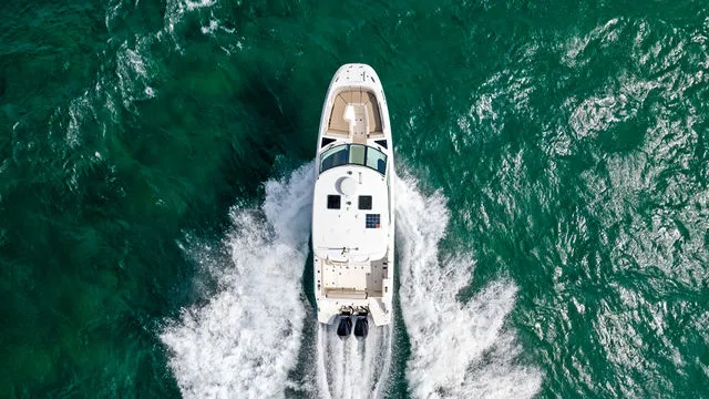 Slide: The Image of 2020 Boston Whaler 320 Vantage boat interior with helm, seating, and marina view. - 58