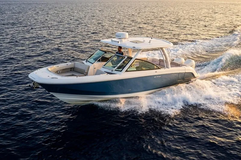 Slide: The Image of 2019 Boston Whaler 320 Vantage cruising on open water at sunset. - 6