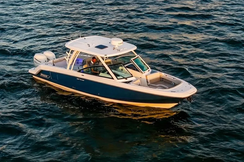 Slide: The Image of 2019 Boston Whaler 320 Vantage boat cruising on open water at sunset. - 7