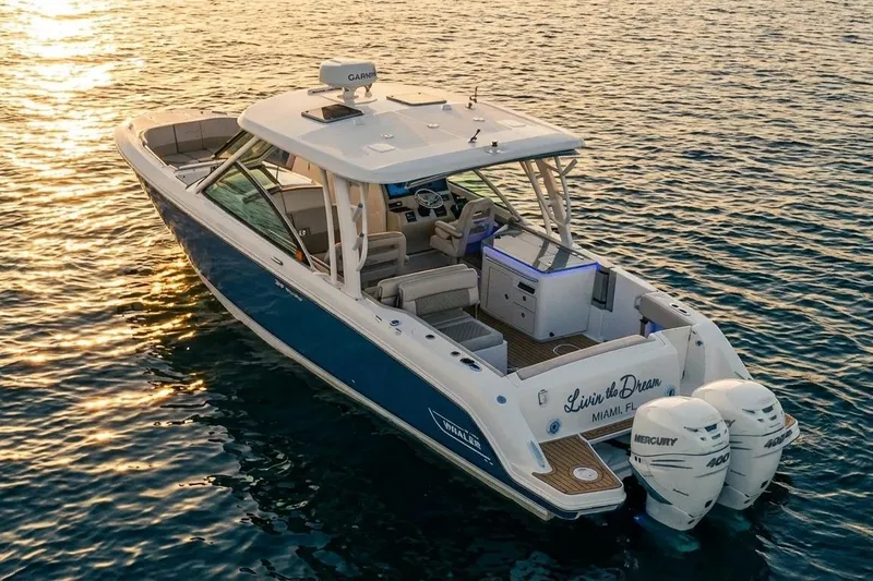 Slide: The Image of 2019 Boston Whaler 320 Vantage boat on water at sunset, featuring dual Mercury engines. - 8