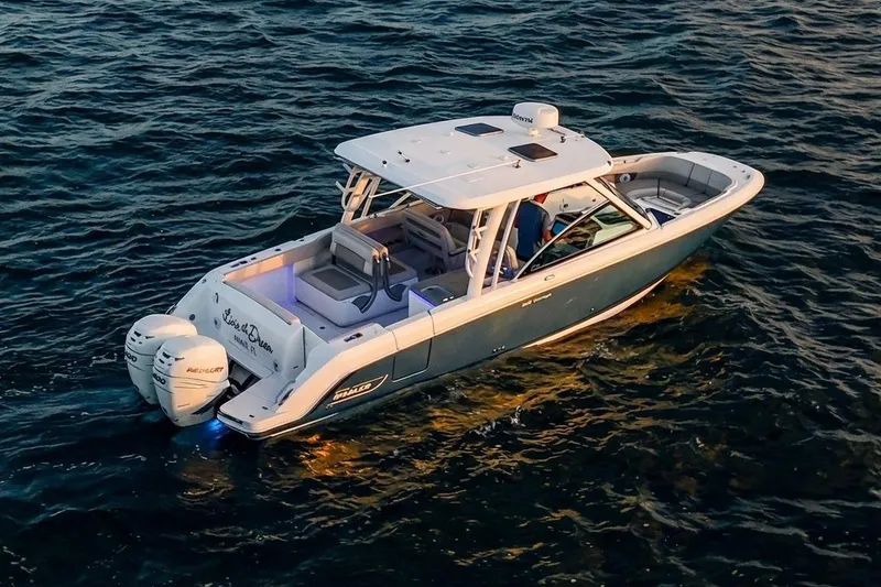 Slide: The Image of 2019 Boston Whaler 320 Vantage boat cruising on open water at sunset. - 9