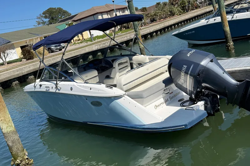 The Image of 2020 Cobalt CS23 boat docked with Yamaha outboard motor, blue canopy, and white interior. - 1
