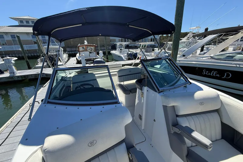 Slide: The Image of 2020 Cobalt CS23 boat docked at marina with canopy and seating. - 7