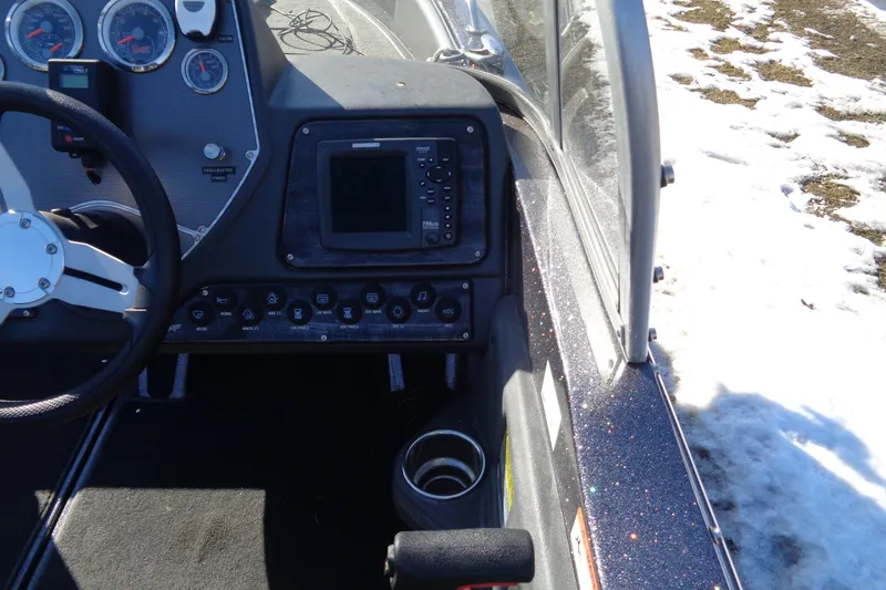 Slide: The Image of 2014 Ranger 1850 LS boat dashboard with steering wheel and control panel in snowy setting. - 33