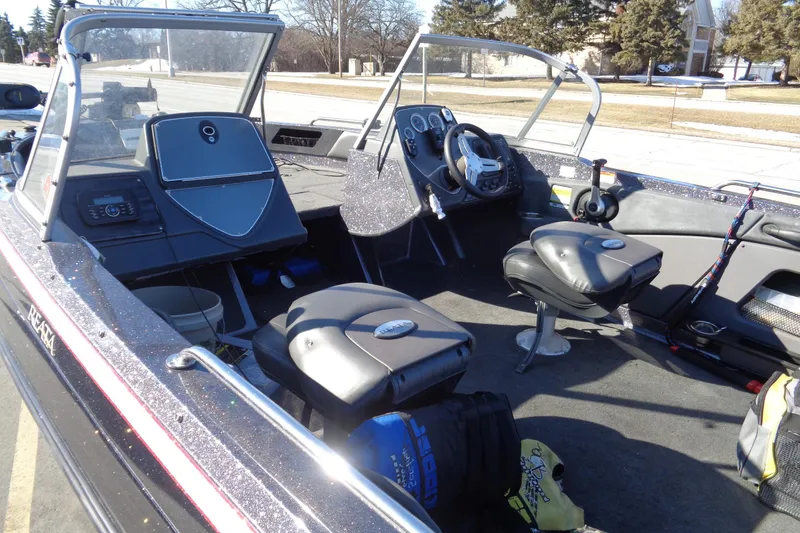 Slide: The Image of 2014 Ranger 1850 LS boat interior with seating, steering wheel, and fishing gear. - 5