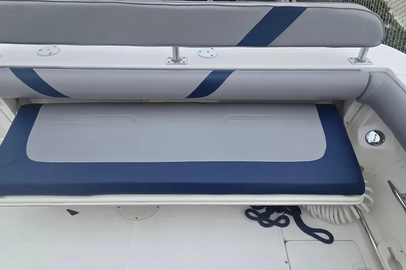 Slide: The Image of 2006 Boston Whaler 320 Outrage Cuddy Cabin seating area with blue and gray upholstery. - 17