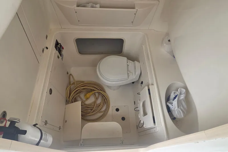 Slide: The Image of 2006 Boston Whaler 320 Outrage Cuddy Cabin interior with toilet and storage space. - 21