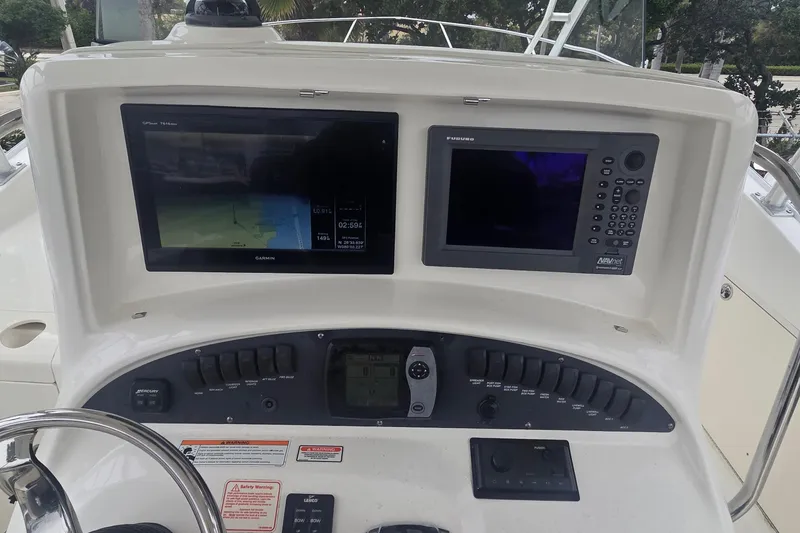 Slide: The Image of 2006 Boston Whaler 320 Outrage Cuddy Cabin dashboard with Garmin and Furuno navigation systems. - 7