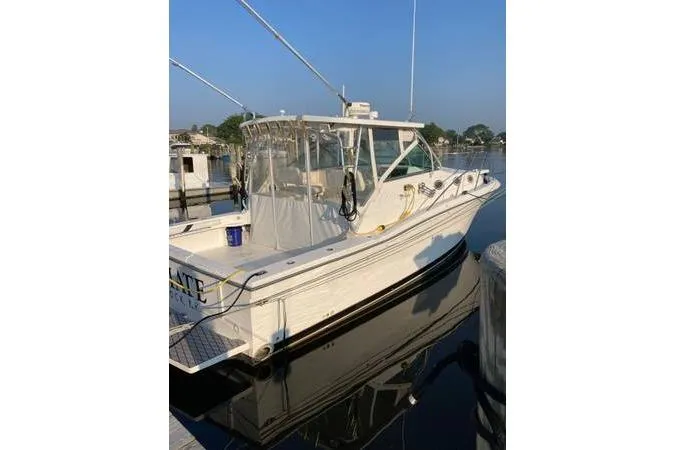 Slide: The Image of 1999 Wellcraft 330 Coastal boat docked at marina, clear sky, calm water. - 3