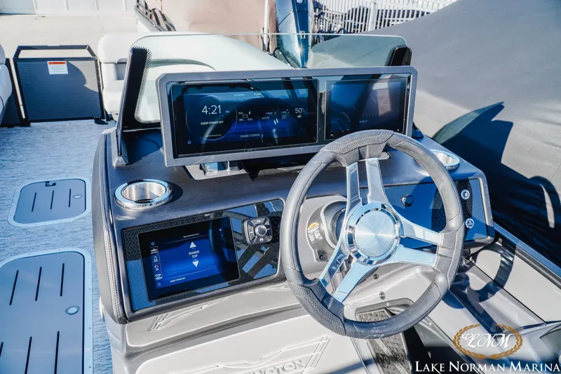 Slide: The Image of 2026 Bennington 24MSB boat dashboard with modern steering and digital displays at Lake Norman Marina. - 11